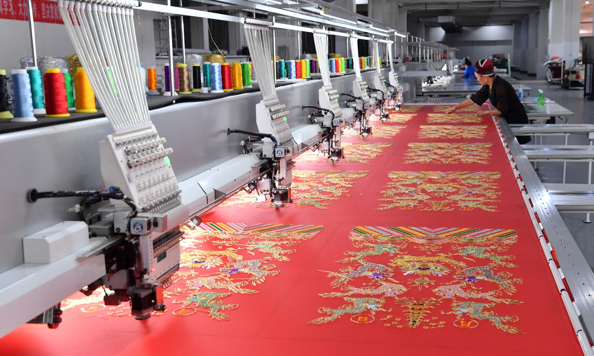 Technicians operate an automated embroidery production line at a tourism commodity development company in Qiandongnan Miao and Dong Autonomous Prefecture, Southwest China's Guizhou Province, on July 13, 2023. Photo: VCG