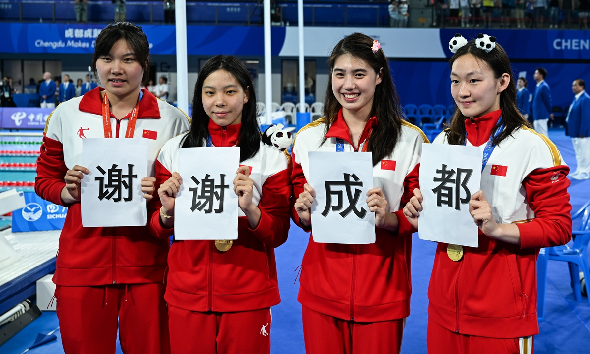 (From left) Liu Yaxin, Zhu Leiju, Zhang Yufei and Li Bingjie hoist cards with the phrase 
