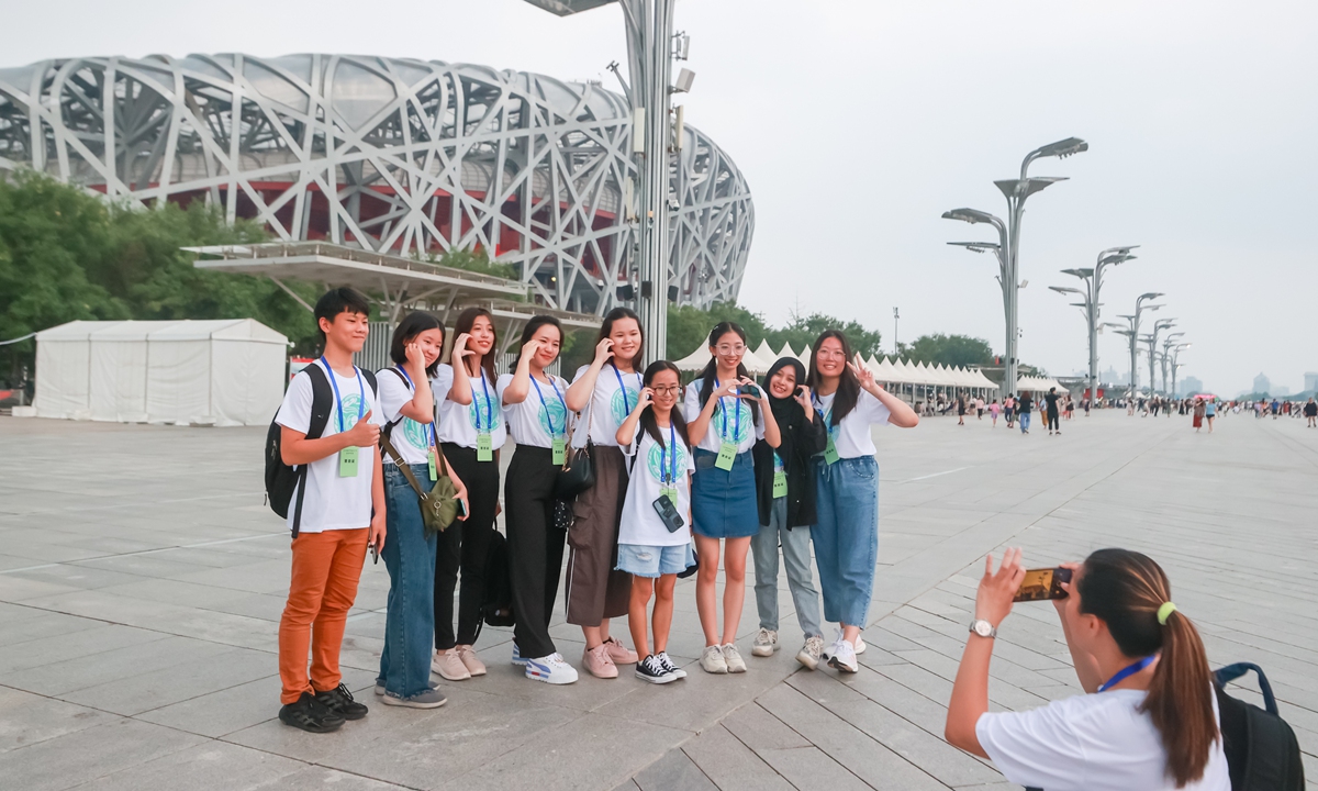 A group of overseas Chinese teenagers have a photo taken inside the Beijing Olympic Park on August 8, 2023.