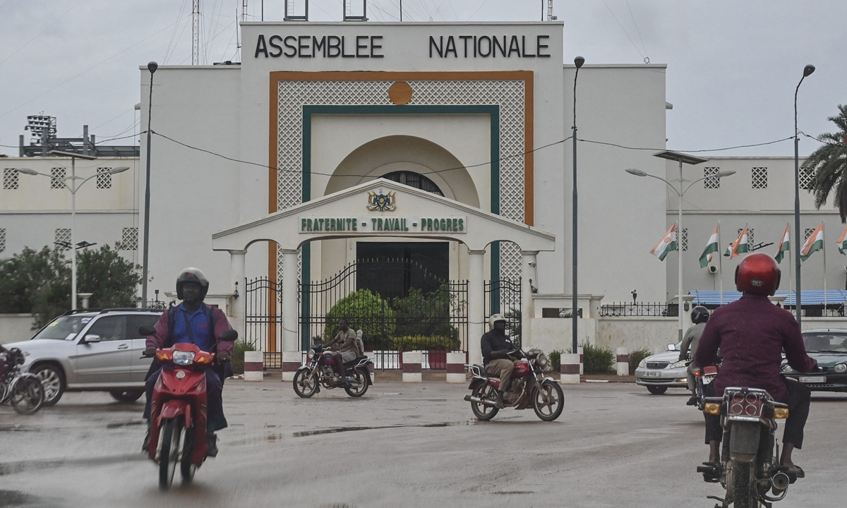 Motorists drive past the National Assembly in Niamey, Niger on August 7, 2023. Niger's junta closed the country's airspace on August 6 until further notice, citing the threat of military intervention from their neighbors. It came after the ECOWAS group of West African states demanded President Mohamed Bazoum be reinstated. Photo: AFP