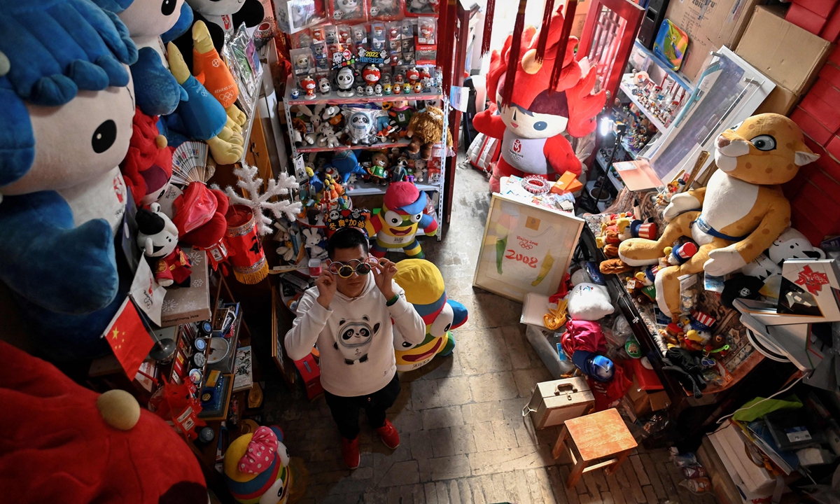  Olympic superfan Zhang Wenquan standing amid his collection of Olympic souvenirs at his home in Beijing on December 30, 2021.