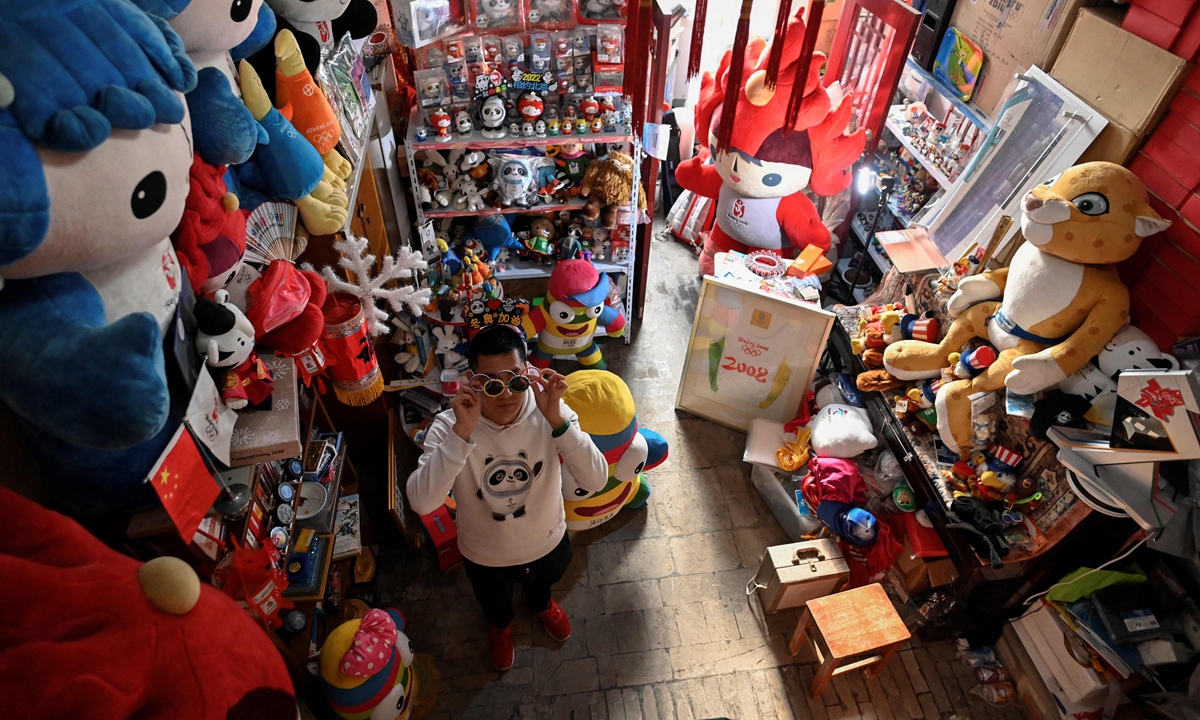  Olympic superfan Zhang Wenquan standing amid his collection of Olympic souvenirs at his home in Beijing on December 30, 2021.