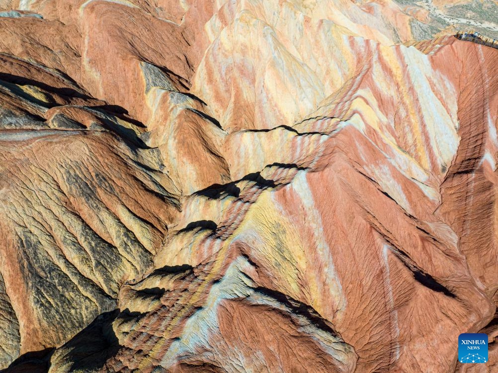 This aerial photo taken on Aug. 7, 2023 shows a view of Danxia landform at Danxia National Geological Park in Zhangye, northwest China's Gansu Province. Boasting a unique type of geomorphology formed from red-colored sandstones and characterized by steep cliffs, the Danxia National Geological Park has attracted an average of over 35,000 visitors daily since August.(Photo: Xinhua)