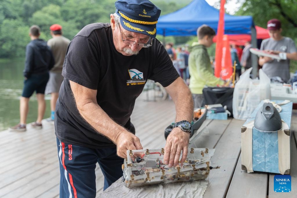 A man repairs his ship model in Vladivostok, Russia, Aug. 8, 2023. An international ship-modeling race took place here on Tuesday, attracting about 50 players bringing different classes of ship models to the event.(Photo: Xinhua)