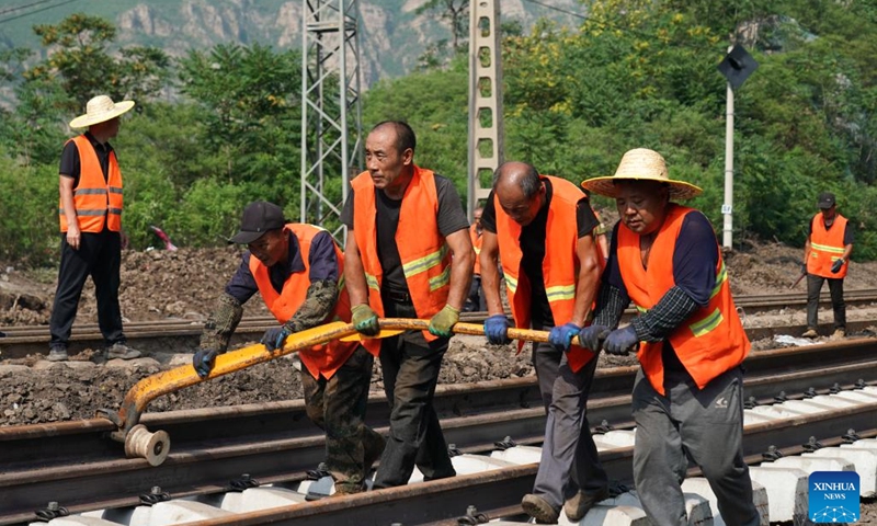Staff members repair a flood-damaged section of Fengtai-Shacheng Railway in Beijing, capital of China, on Aug. 8, 2023. A track-confirming engine safely passed Zhuwo Station along Fengtai-Shacheng Railway on Tuesday evening, which marked the complete restoration of this flood-damaged railway after 71 hours of emergency repairing. The railway line connects Fengtai of Beijing and Shacheng Township of Zhangjiakou City in north China's Hebei Province.(Photo: Xinhua)