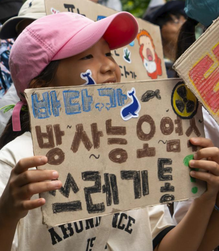 A child attends a rally to protest against the Japanese government's plan to discharge nuclear-contaminated wastewater into the sea in Seoul, South Korea, Aug. 12, 2023. (Photo by James Lee/Xinhua)