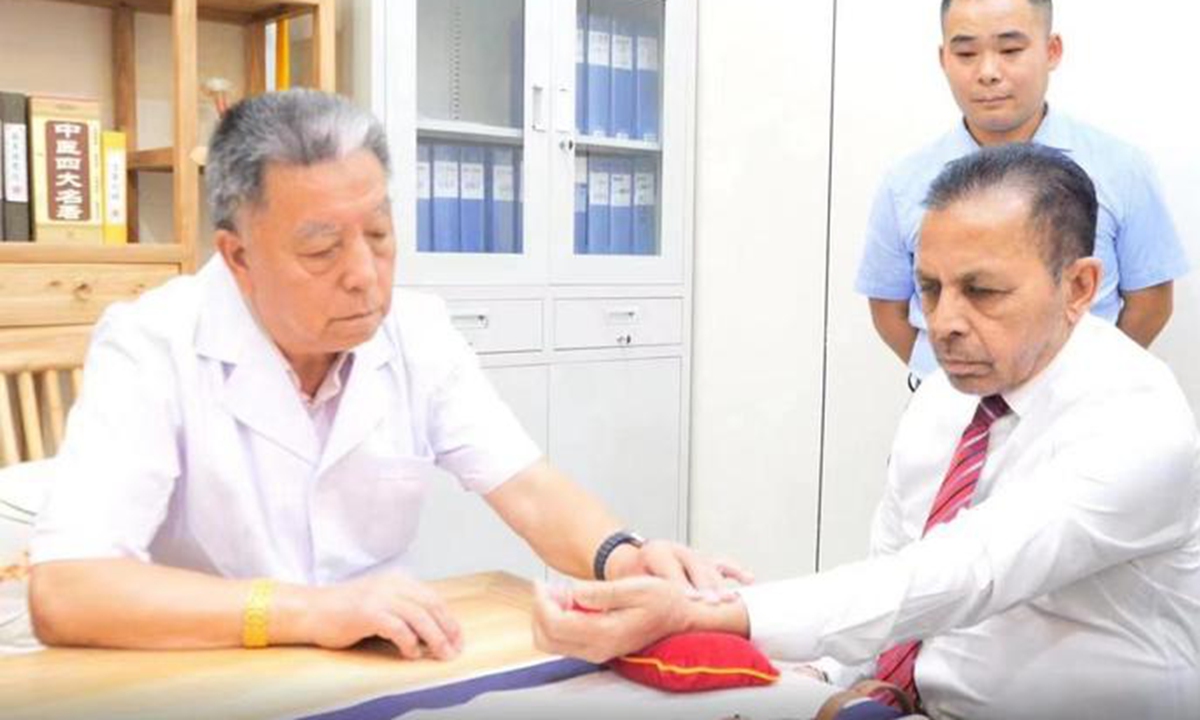 Sri Lankan Ambassador to China Palitha Kohona has his pulse taken by a TCM practitioner. Photo: Courtesy of the Beijing Hanyitang TCM Hospital 