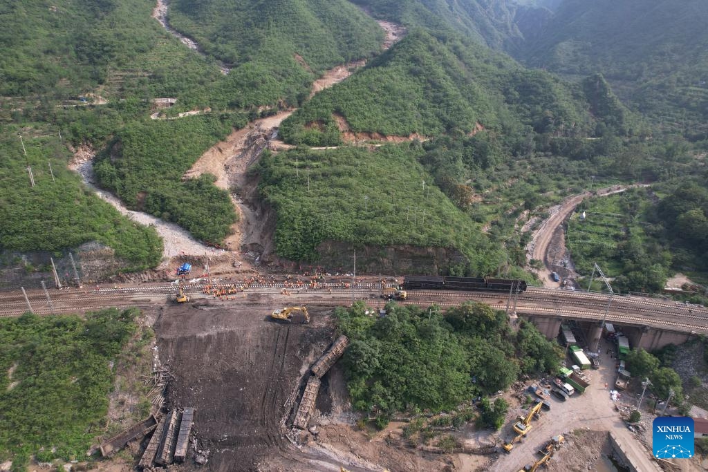 This aerial photo shows staff members repairing a flood-damaged section of Fengtai-Shacheng Railway in Beijing, capital of China, on Aug. 8, 2023. A track-confirming engine safely passed Zhuwo Station along Fengtai-Shacheng Railway on Tuesday evening, which marked the complete restoration of this flood-damaged railway after 71 hours of emergency repairing. The railway line connects Fengtai of Beijing and Shacheng Township of Zhangjiakou City in north China's Hebei Province.(Photo: Xinhua)