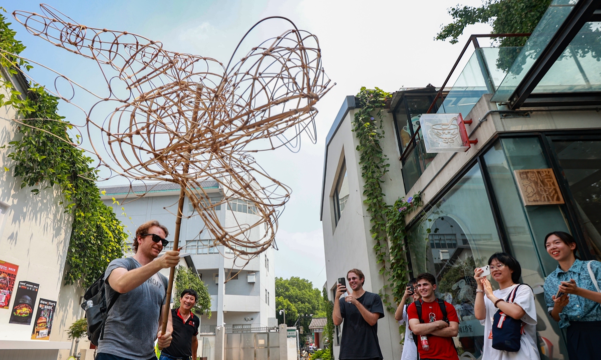 A foreign tourist plays with a Qinhuai Lantern while visiting a lantern maker's studio in Nanjing, East China's Jiangsu Province on August 13, 2023. The Qinhuai Lantern Festival was listed as a national intangible cultural heritage in 2006. Photo: VCG