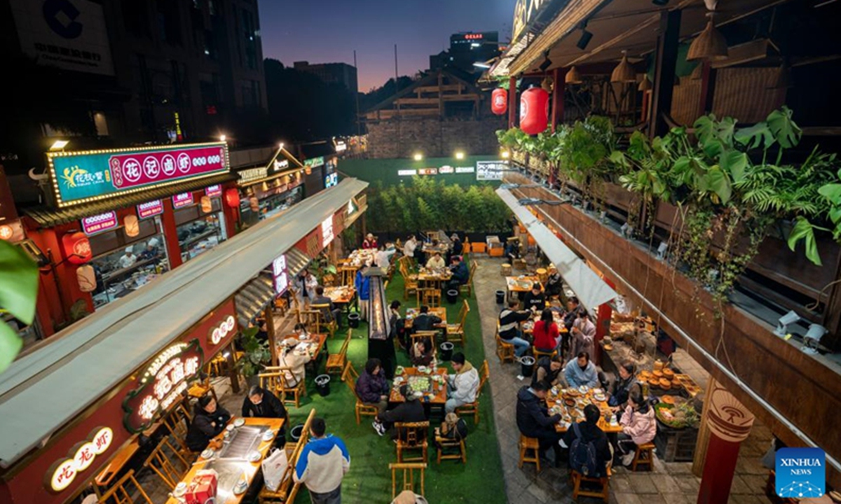 Residents dine out in a restaurant in the Nanqiang Street of Kunming, southwest China's Yunnan Province, Jan. 11, 2023. The street, located in downtown Kunming, has seen a robust recovery of the nighttime economy. Tourists here can experience local food culture and nightlife of Kunming.(Photo: Xinhua)