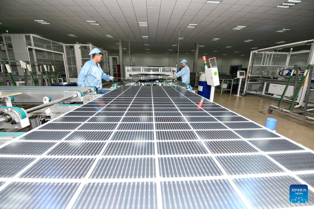 Workers produce photovoltaic modules at the workshop of a new energy company in Yi-Hui-Miao Autonomous County of Weining, southwest China's Guizhou Province, July 19, 2023. Guizhou has seized the opportunity and made big stride in the development of new energy industry, such as wind power and photovoltaic power, in recent years. While vigorously developing green energy, Guizhou has also made full use of the land under photovoltaic panels to develop farming and livestock breeding.(Photo: Xinhua)
