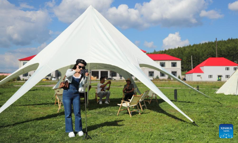 Tourists take pictures at a resort in Arxan of Hinggan League, north China's Inner Mongolia Autonomous Region, Sept. 1, 2023. Arxan, located at the southwestern foot of the Dahinggan Mountains and at the intersection of four major grasslands, is an increasingly popular tourist destination. (Xinhua/Wang Kaiyan)