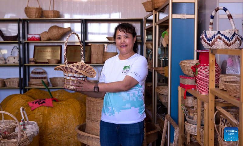 Villager Dong Yali displays willow wares at Xikou Village in Arxan of Hinggan League, north China's Inner Mongolia Autonomous Region, Sept. 2, 2023. Arxan, located at the southwestern foot of the Dahinggan Mountains and at the intersection of four major grasslands, is an increasingly popular tourist destination. (Xinhua/Li Zhipeng)