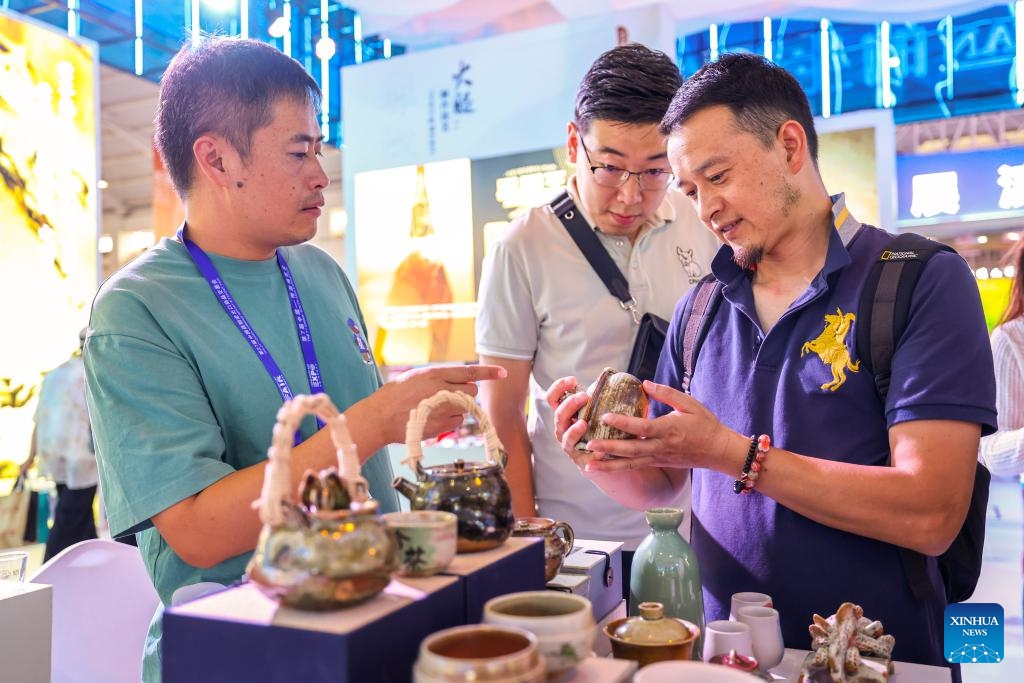 An exhibitor (L) introduces pottery products to visitors at the 7th China-South Asia Exposition in Kunming, southwest China's Yunnan Province, Aug. 17, 2023. The 7th China-South Asia Exposition opened here on Wednesday.(Photo: Xinhua)