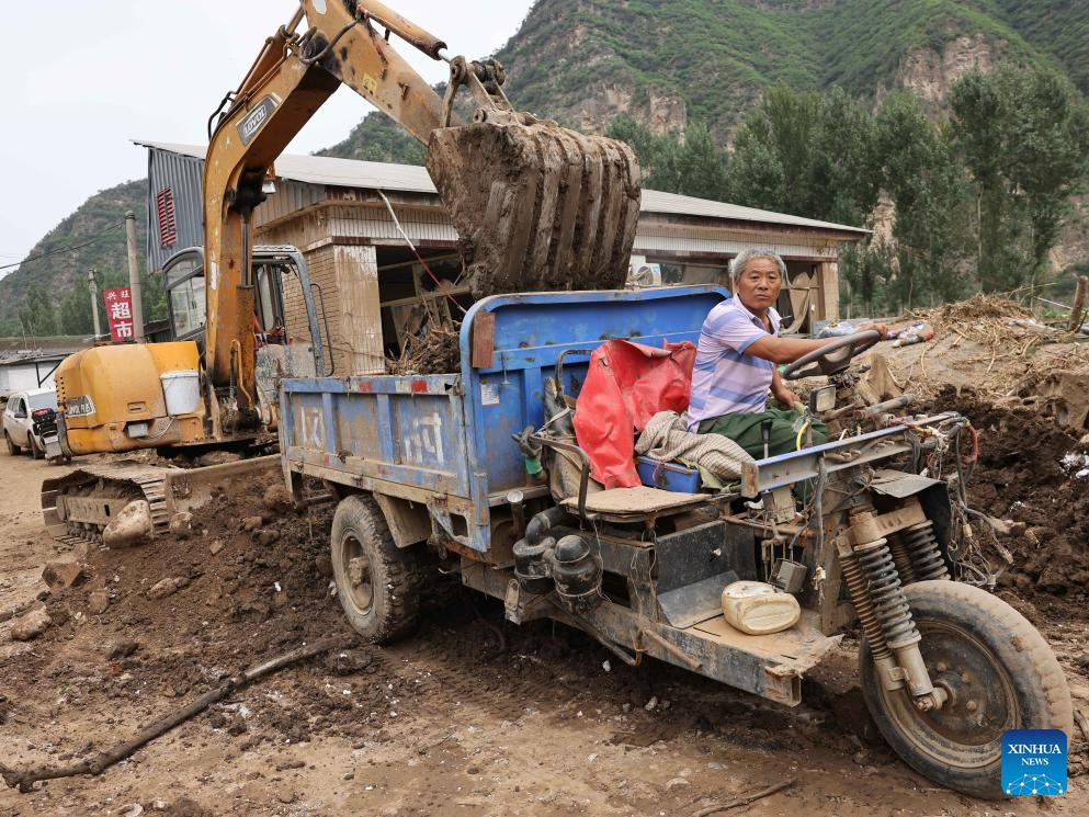 Villager Zhang Chengshan drives a tractor to transfer silt at Pingyu Village of Laishui County, north China's Hebei Province, Aug. 17, 2023. Laishui County has suffered heavy rainfall due to the impact of Typhoon Doksuri recently. Local authorities have actively carried out post-disaster emergency reconstruction to ensure that residents stay safe and help floods-hit regions back on track.(Photo: Xinhua)