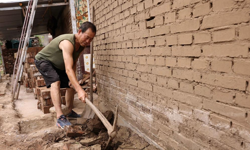 Villager Zhao Minglin cleans up a drainage ditch at Pingyu Village of Laishui County, north China's Hebei Province, Aug. 17, 2023. Laishui County has suffered heavy rainfall due to the impact of Typhoon Doksuri recently. Local authorities have actively carried out post-disaster emergency reconstruction to ensure that residents stay safe and help floods-hit regions back on track(Photo: Xinhua)