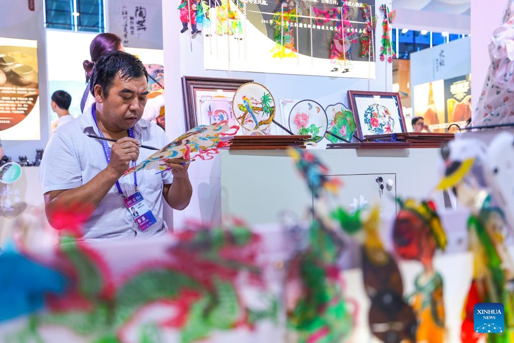 An exhibitor paints a Chinese shadow puppet at the 7th China-South Asia Exposition in Kunming, southwest China's Yunnan Province, Aug. 17, 2023. The 7th China-South Asia Exposition opened here on Wednesday.(Photo: Xinhua)