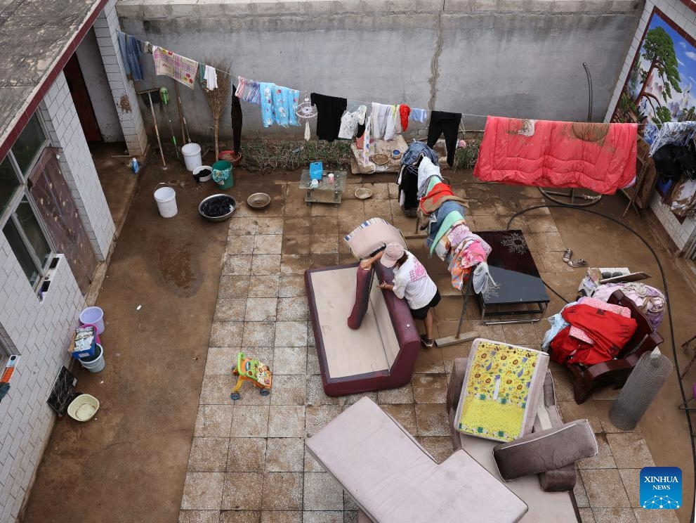 Villager Zhao Guojin cleans up furniture in her yard at Pingyu Village of Laishui County, north China's Hebei Province, Aug. 17, 2023. Laishui County has suffered heavy rainfall due to the impact of Typhoon Doksuri recently. Local authorities have actively carried out post-disaster emergency reconstruction to ensure that residents stay safe and help floods-hit regions back on track.(Photo: Xinhua)