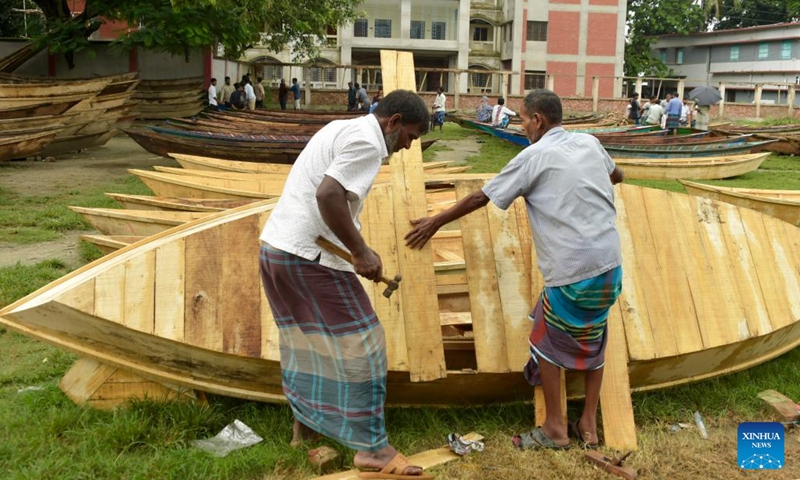 Carpenters make a wooden boat at an open-air marketplace in Manikganj district, Bangladesh, Aug. 23, 2023. Sales of the traditional small boats usually increase at this time of the year. In this part of Bangladesh, water transportation is still an important means of communication during the monsoon season from June to September.(Photo: Xinhua)