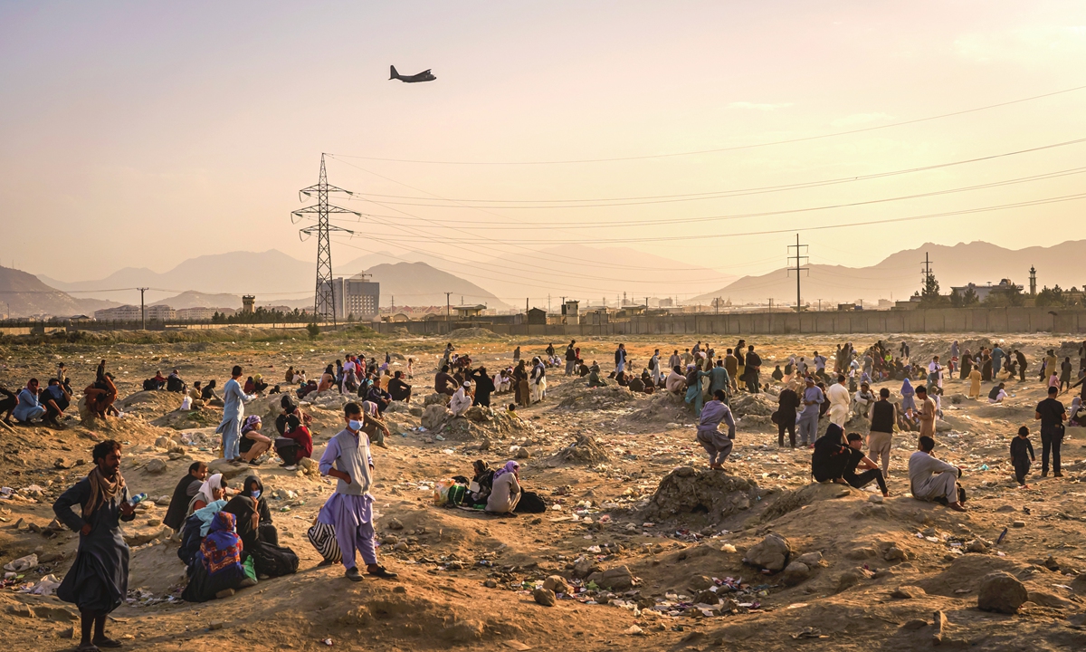 A military transport plane takes off while Afghans, who cannot get into the airport to evacuate, watch and wonder while stranded outside, in Kabul, Afghanistan, August 23, 2021. Photo: VCG