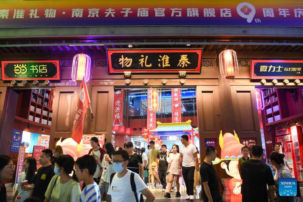 Tourists select souvenirs at a gift shop at the Fuzi (Confucius) Temple scenic area in Nanjing, east China's Jiangsu Province, Aug. 18, 2023. Qinhuai District of Nanjing has been boosting and diversifying its tourism economy in recent years through joint efforts in entertainment, sightseeing, catering and shopping services. A number of tourist attractions designed for nighttime visit were established there to enrich the nightlife of both tourists and local residents, and infuse new vigor into urban consumption.(Photo: Xinhua)