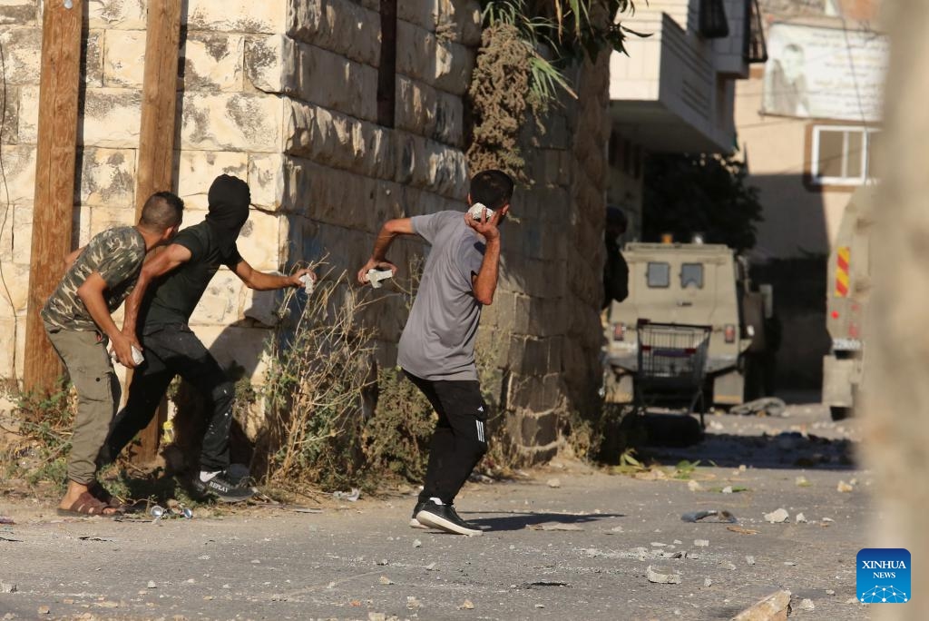 Palestinian protesters hurl stones at Israeli soldiers during clashes following an Israeli raid in the village of Beita near the West Bank city of Nablus, on Aug. 21, 2023. Dozens of Palestinians were injured on Monday during clashes with the Israeli soldiers at the Gaza border with Israel and the West Bank, Palestinian medics and eyewitnesses said.(Photo: Xinhua)