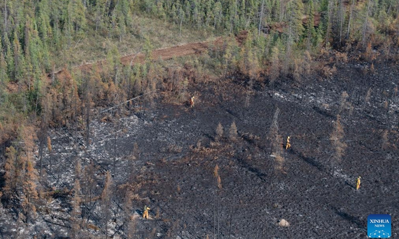 This photo taken on Aug. 21, 2023 shows members of the Canadian Armed Forces walking on a scorched land near Hay River in Northwest Territories, Canada.(Photo: Xinhua)