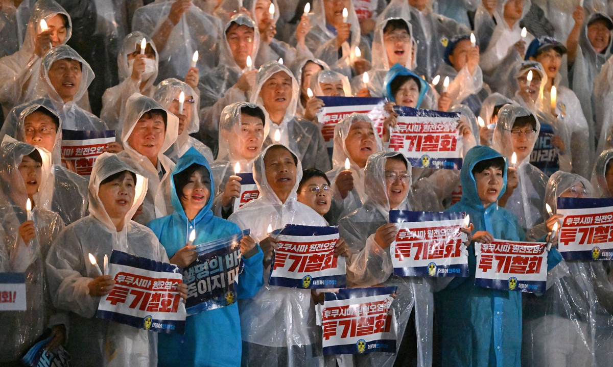 South Korea's main opposition Democratic Party members hold electric candles and signs reading 
