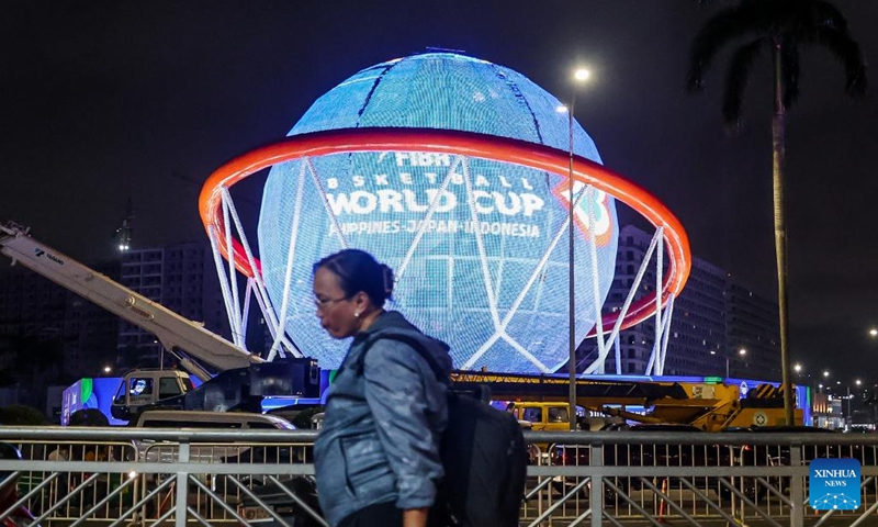 People walk past a giant FIBA Basketball World Cup themed display in Pasay City, the Philippines, Aug. 24, 2023. The FIBA Basketball World Cup 2023 will be held from Aug. 25 to Sept. 10, 2023.(Photo: Xinhua)