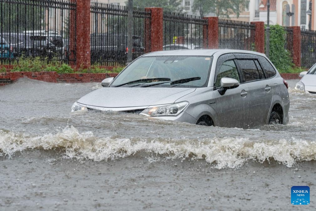A car drives on a flooded street in the center of Vladivostok, Russia, Aug. 23, 2023. The city experienced torrential rain on Wednesday, causing flooding in low-lying areas of the urban area.(Photo: Xinhua)