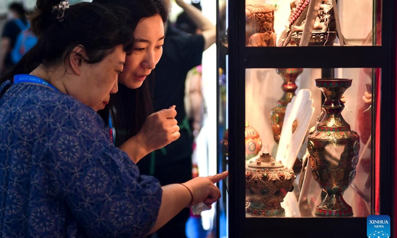 Visitors buy products from Nepal at the 14th China-Northeast Asia Expo in Changchun, the capital city of northeast China's Jilin Province, Aug. 24, 2023. The 14th China-Northeast Asia Expo opened Wednesday in Changchun. The five-day event, scheduled both online and offline, has attracted more than 1,000 companies from home and abroad, with a predominant representation from countries in Northeast Asia.(Photo: Xinhua)