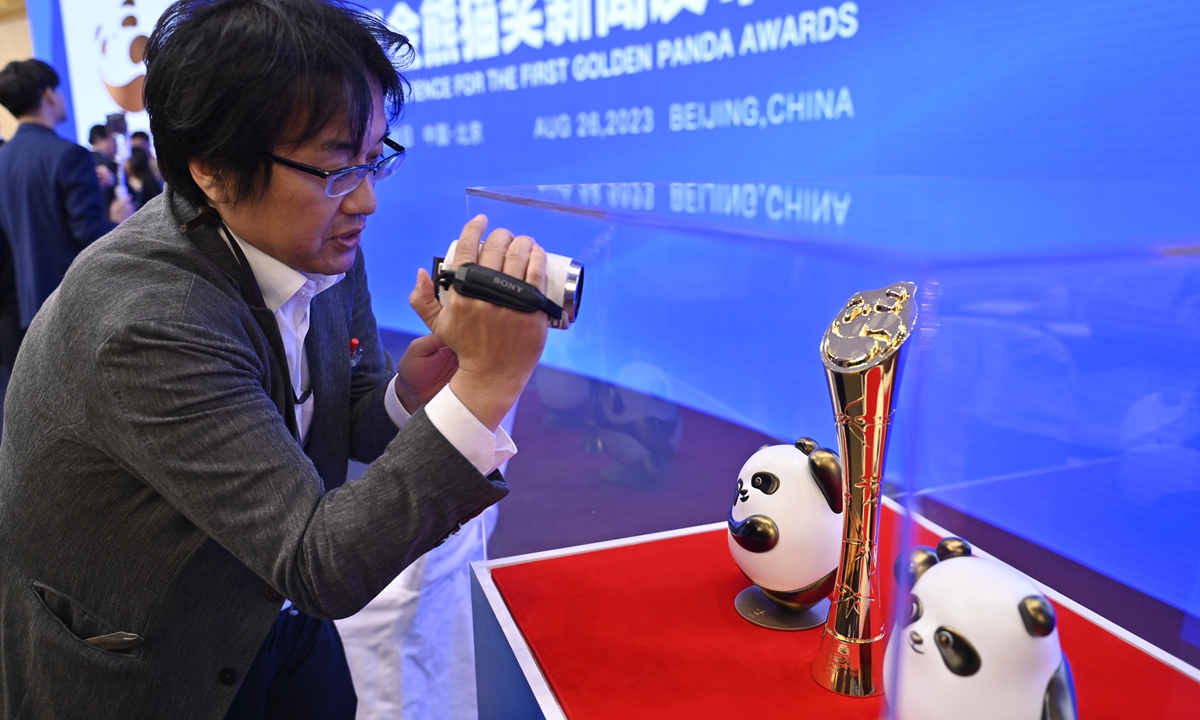 A foreign journalist films the trophy and mascots of the Golden Panda Awards in Beijing on August 26, 2023. Photo: VCG