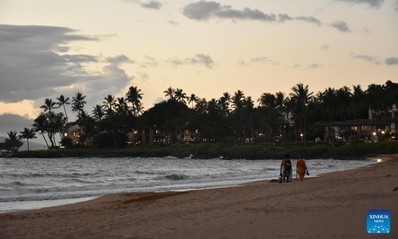 Photo taken on Aug. 23, 2023 shows people walking on an empty beach in Maui, Hawaii, the United States. The devastating wildfires that ravaged the Hawaiian island of Maui were a bitter blow to the island's tourism industry, but local residents and business leaders expect more tourists will come back as the island embarks on a long road ahead for recovery. Photo: Xinhua