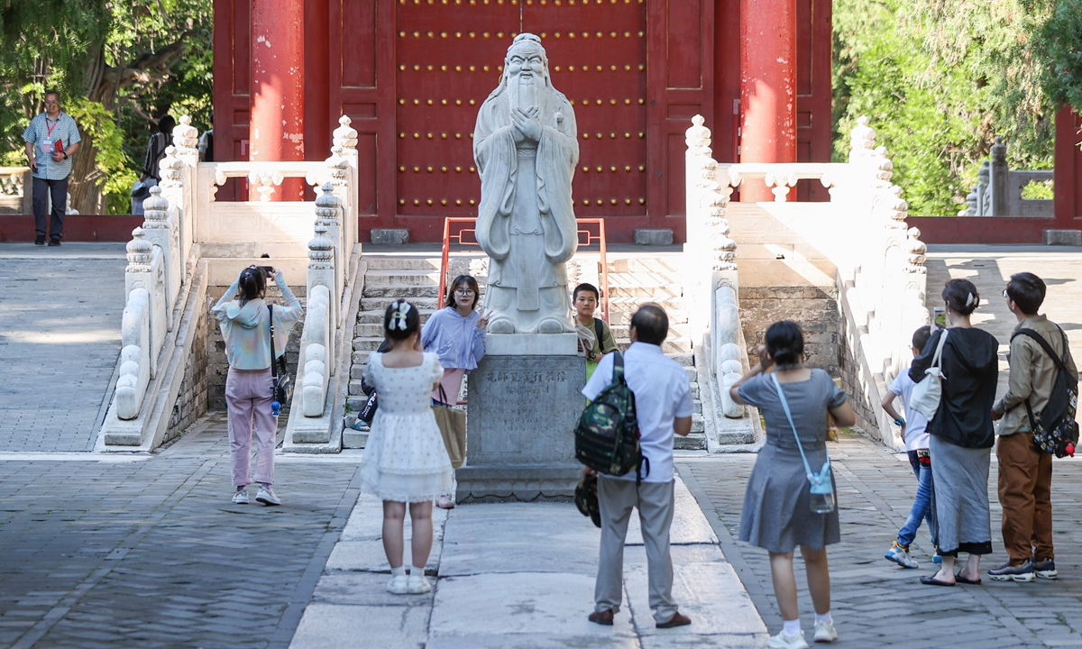 Students and tourists take photos beside the statue of Confucius at the Confucian Temple and the Imperial College in Beijing on August 28, 2023. Students hope to get some good luck before the start of the new semester by paying tribute to Confucius, the founder and master of Confucianism and the paragon of Chinese sages. Photo: VCG