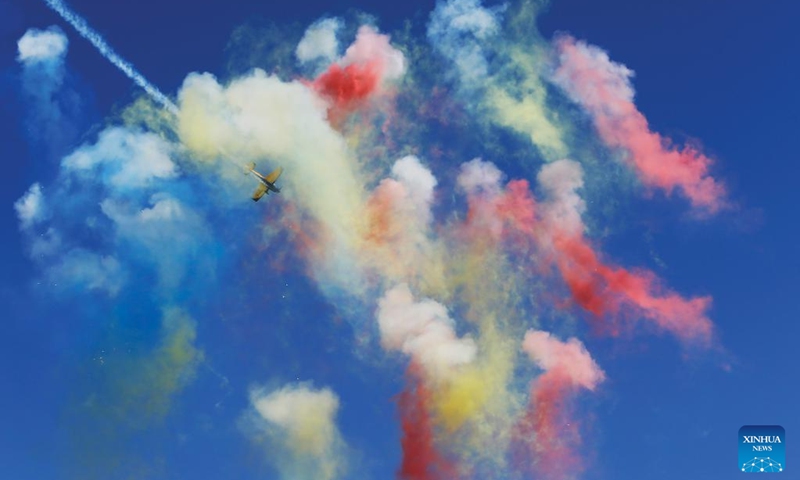 An airplane passes through colored smoke from fireworks during the 2023 Bucharest International Air Show & General Aviation Exhibition in Bucharest, Romania, Aug. 26, 2023. Photo: Xinhua
