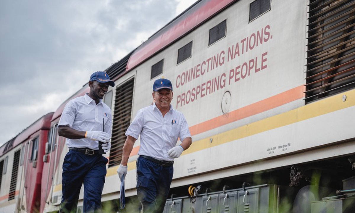 Chinese instructor Jiang Liping (R) and apprentice Horace Owiti walk past a train carriage on the Mombasa-Nairobi Railway in Nairobi, Kenya, May 23, 2023.  (Xinhua/Wang Guansen)

