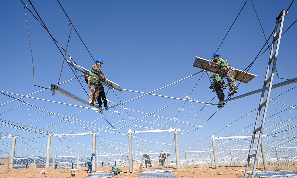 Technicians install photovoltaic sand control project power generation panels in the Kubuqi Desert, on July 22, 2023. Photo: Xinhua