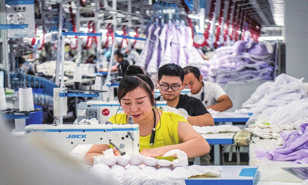  Workers are busy producing export-oriented clothes ordered by overseas clients at a garment factory in Suncun town in Wuhu city, East China’s Anhui Province on August 29, 2023. From January to April this year, China's overall exports of textiles, clothing and accessories totaled $92.88 billion, according to the General Administration of Customs of China. Photo:cnsphoto