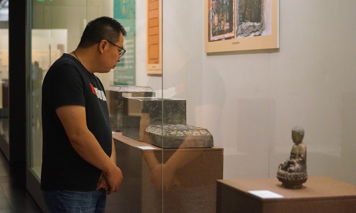A visitor looks at a cultural relic at the Fahua Tower exhibition on August 30, 2023. (Photo: Lu Ting/GT)