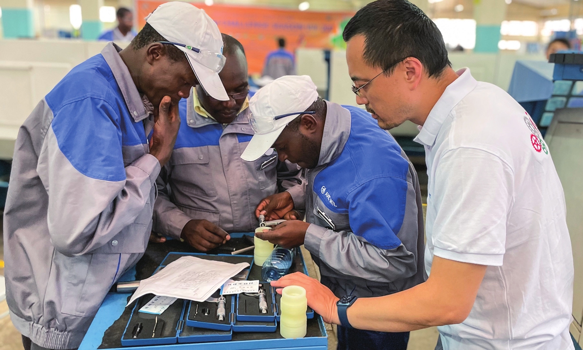 A Chinese instructor guides participants in the Africa Tech Challenge on machine operation. Photo: Liu Xin/GT
