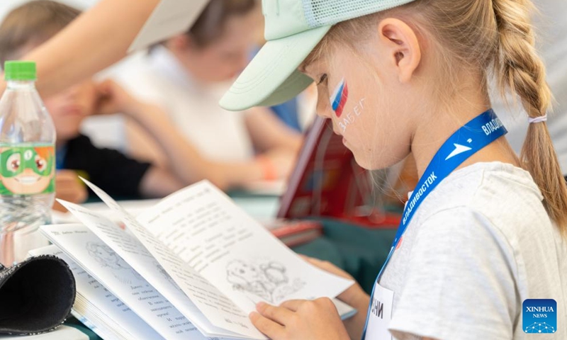 A girl reads a book during a Knowledge Day event to celebrate the start of the new school year on the central square of Vladivostok, Russia, Sept. 2, 2023. Programs like popular sciences, painting, dictation, handicraft, fire safety knowledge and other activities on Knowledge Day attracted many children. Photo: Xinhua