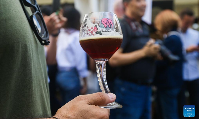 A man holds a glass of beer at the 23rd Belgian Beer Weekend in Brussels, Belgium, Sept. 2, 2023. More than 500 Belgian beers were presented by 53 breweries to the public during the event.  Photo: Xinhua