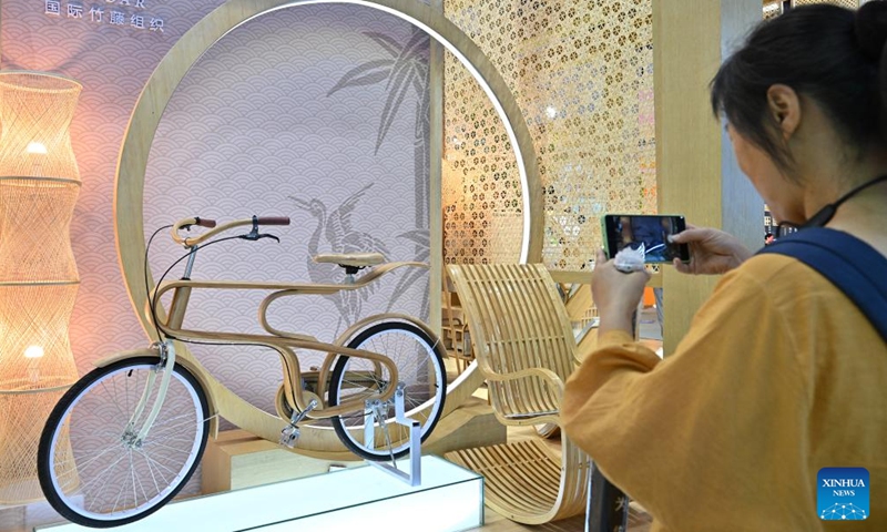 A visitor takes photos of a bicycle made of bamboo at the environmental services exhibition of the 2023 China International Fair for Trade in Services (CIFTIS) in Beijing, capital of China, Sept. 2, 2023. Themed Opening-up leads development, cooperation delivers the future, the 2023 CIFTIS is being held in Beijing from Sept. 2 to 6 and features over 200 varied events, including forums, negotiations, and summits. (Photo: Xinhua)