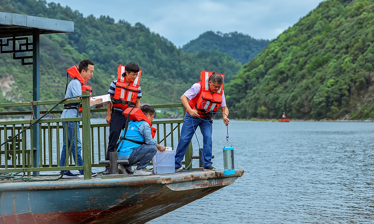Environmental department workers from Chun’an county of Zhejiang and Shexian county of Anhui take samples from the Xin’an River during a joint monitoring activity on August 31, 2023. Photo: VCG