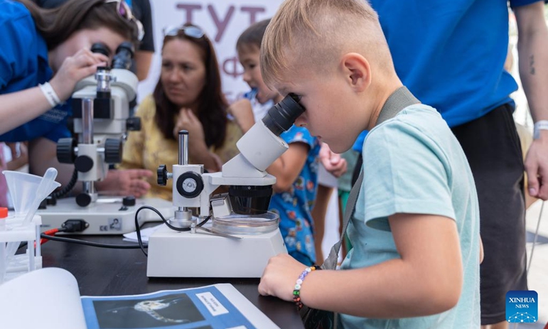 A boy observes through a microscope during a Knowledge Day event to celebrate the start of the new school year on the central square of Vladivostok, Russia, Sept. 2, 2023. Programs like popular sciences, painting, dictation, handicraft, fire safety knowledge and other activities on Knowledge Day attracted many children. Photo: Xinhua