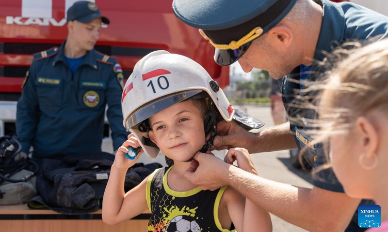 A boy tries on a fire helmet during a Knowledge Day event to celebrate the start of the new school year on the central square of Vladivostok, Russia, Sept. 2, 2023. Programs like popular sciences, painting, dictation, handicraft, fire safety knowledge and other activities on Knowledge Day attracted many children. Photo: Xinhua
