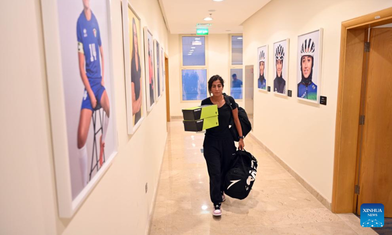 An athlete walks with her baggage for the upcoming Hangzhou Asian Games at the Kuwait Olympic Committee in Jahra Governorate, Kuwait, Sept. 10, 2023. (Photo by Asad/Xinhua)