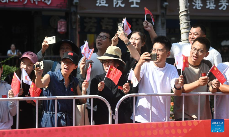 People watch the torch relay of the 19th Asian Games in Shaoxing, east China's Zhejiang Province, Sept. 11, 2023. (Xinhua/Xu Yu)