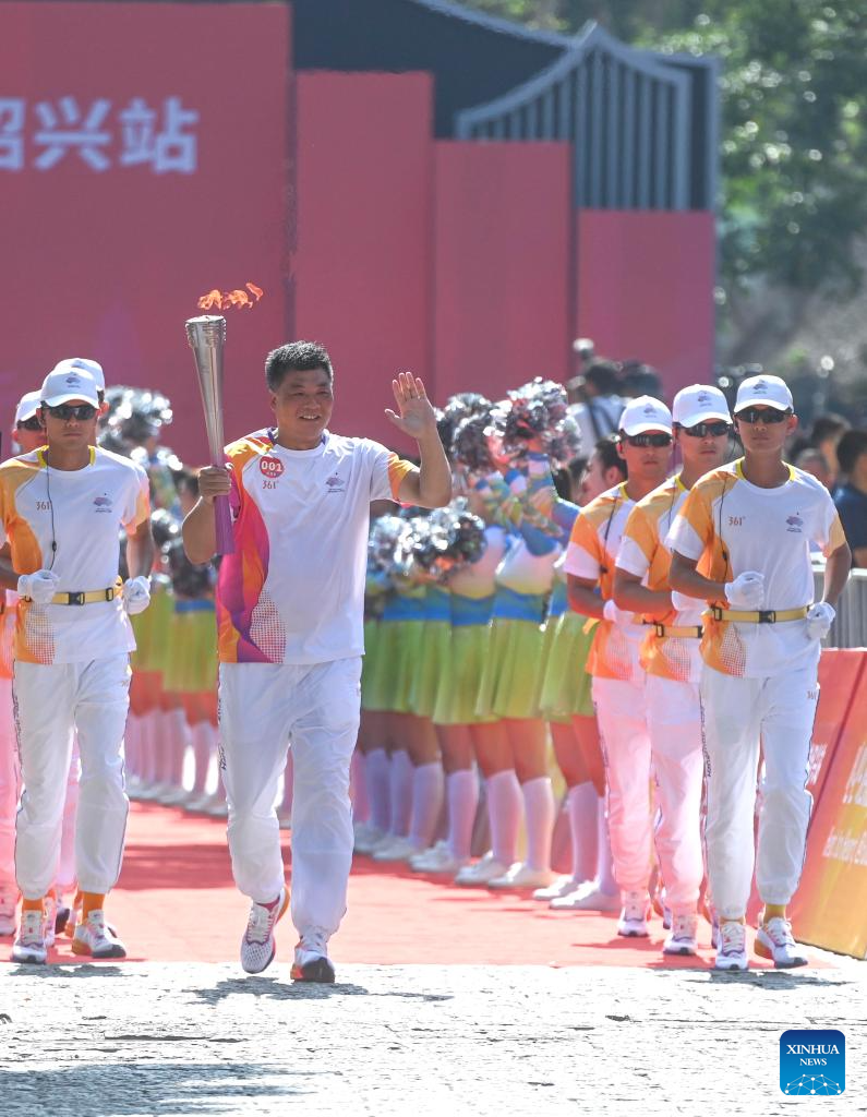 Torch bearer Yu Juemin runs with the torch during the torch relay of the 19th Asian Games in Shaoxing, east China's Zhejiang Province, Sept. 11, 2023. (Xinhua/Xu Yu)