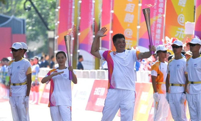 Torch bearers Lu Minjia (L) and Yu Juemin pose during the torch relay of the 19th Asian Games in Shaoxing, east China's Zhejiang Province, Sept. 11, 2023. (Xinhua/Xu Yu)